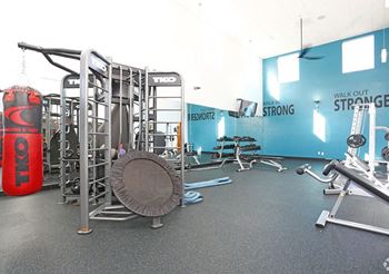 A gym with a red bottle of oil and a weight rack.